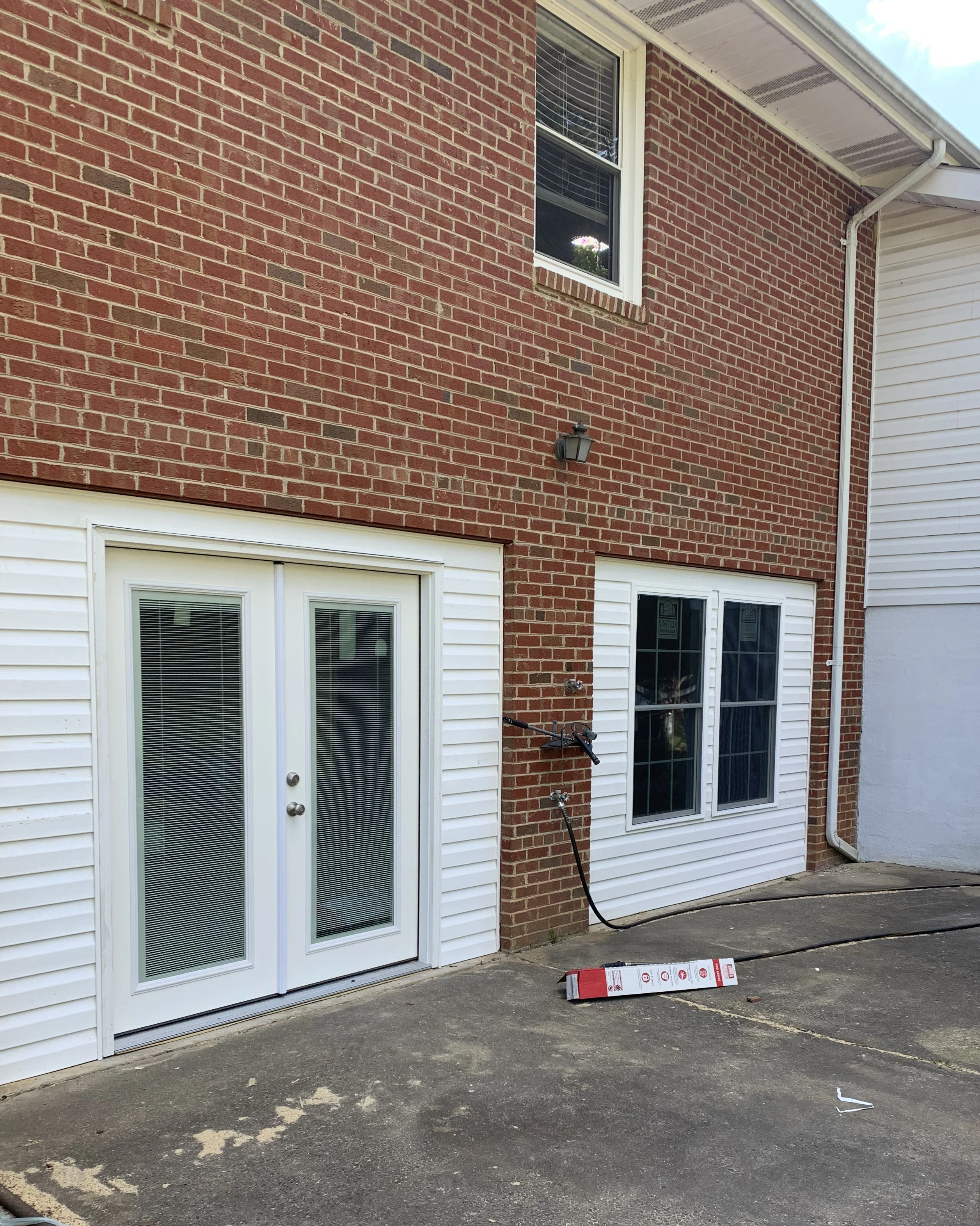Brick exterior with new white French doors and matching white-trimmed windows.