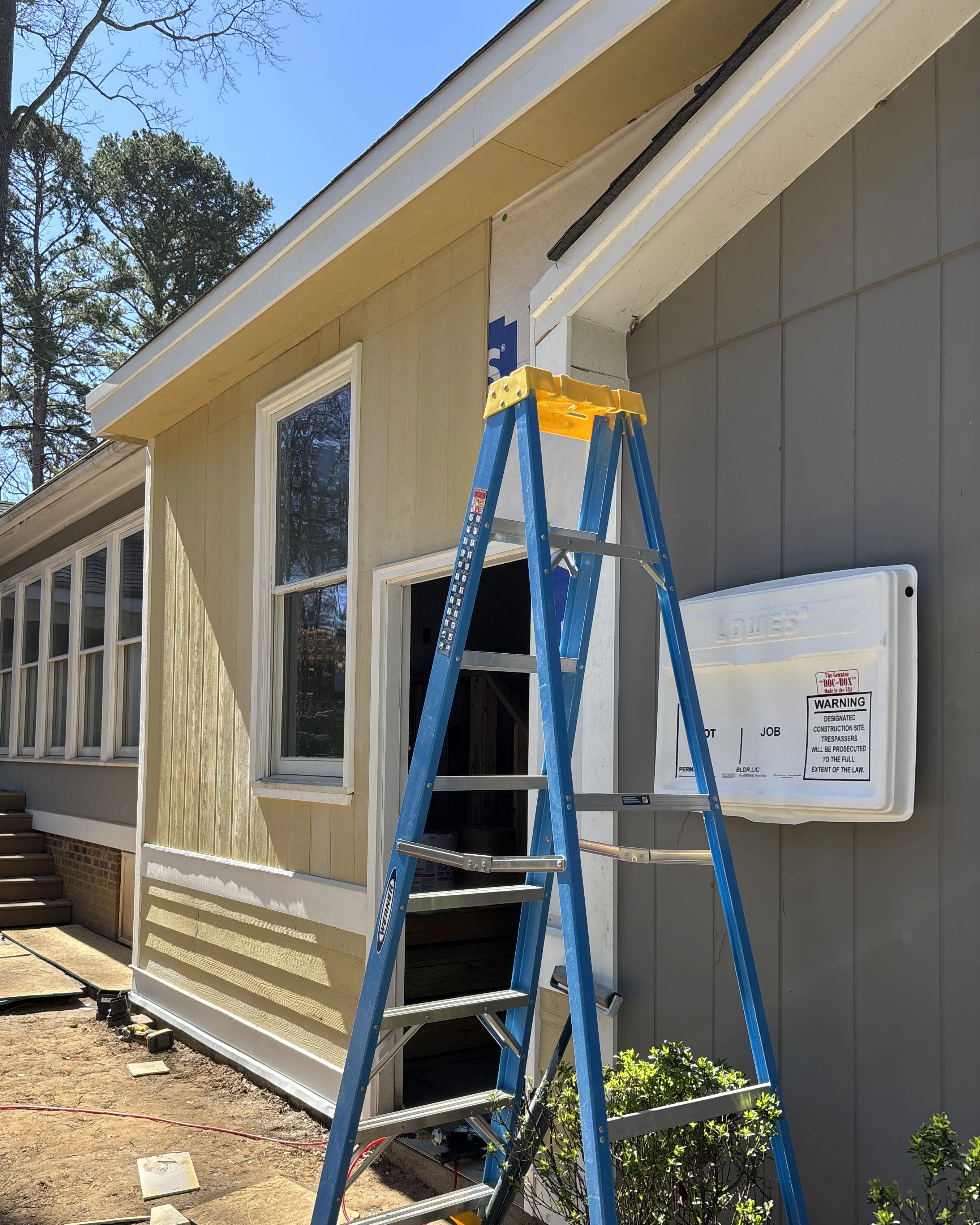 xterior siding and trim repair underway, with new Hardie panels replacing damaged sections.
