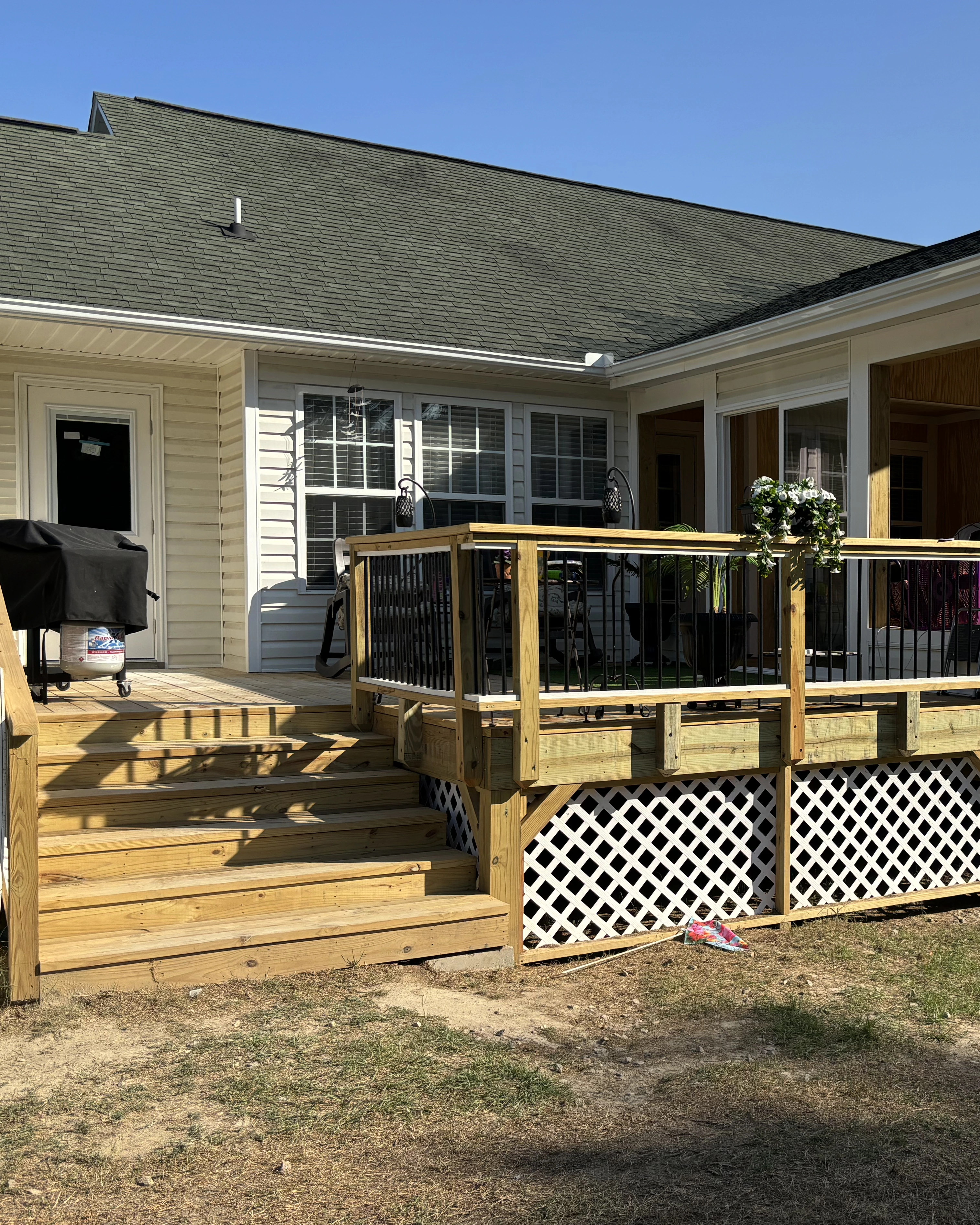 Finished wood deck with white lattice skirting and updated railings.
