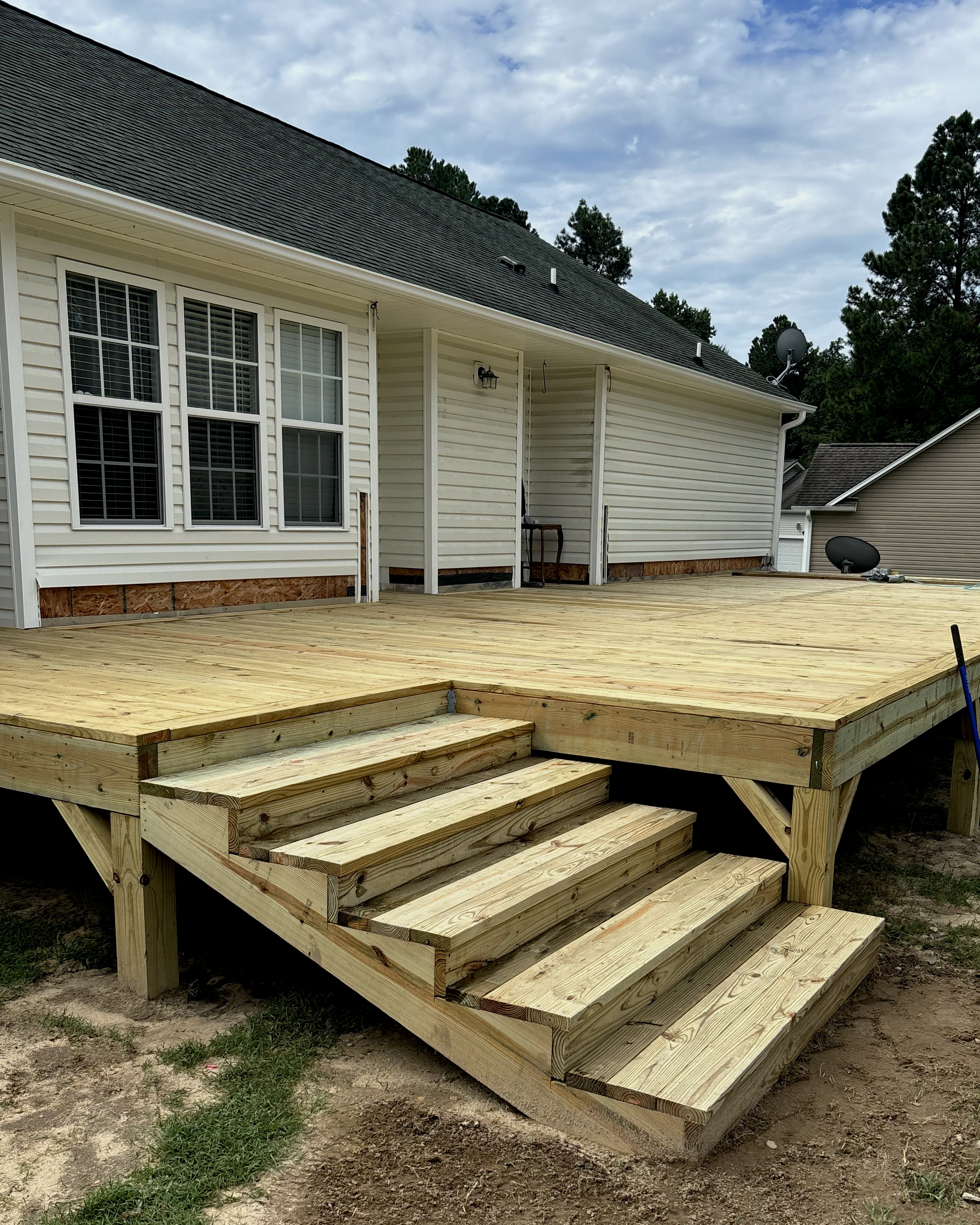 Ground-level deck with wide wood stair entry and open layout.