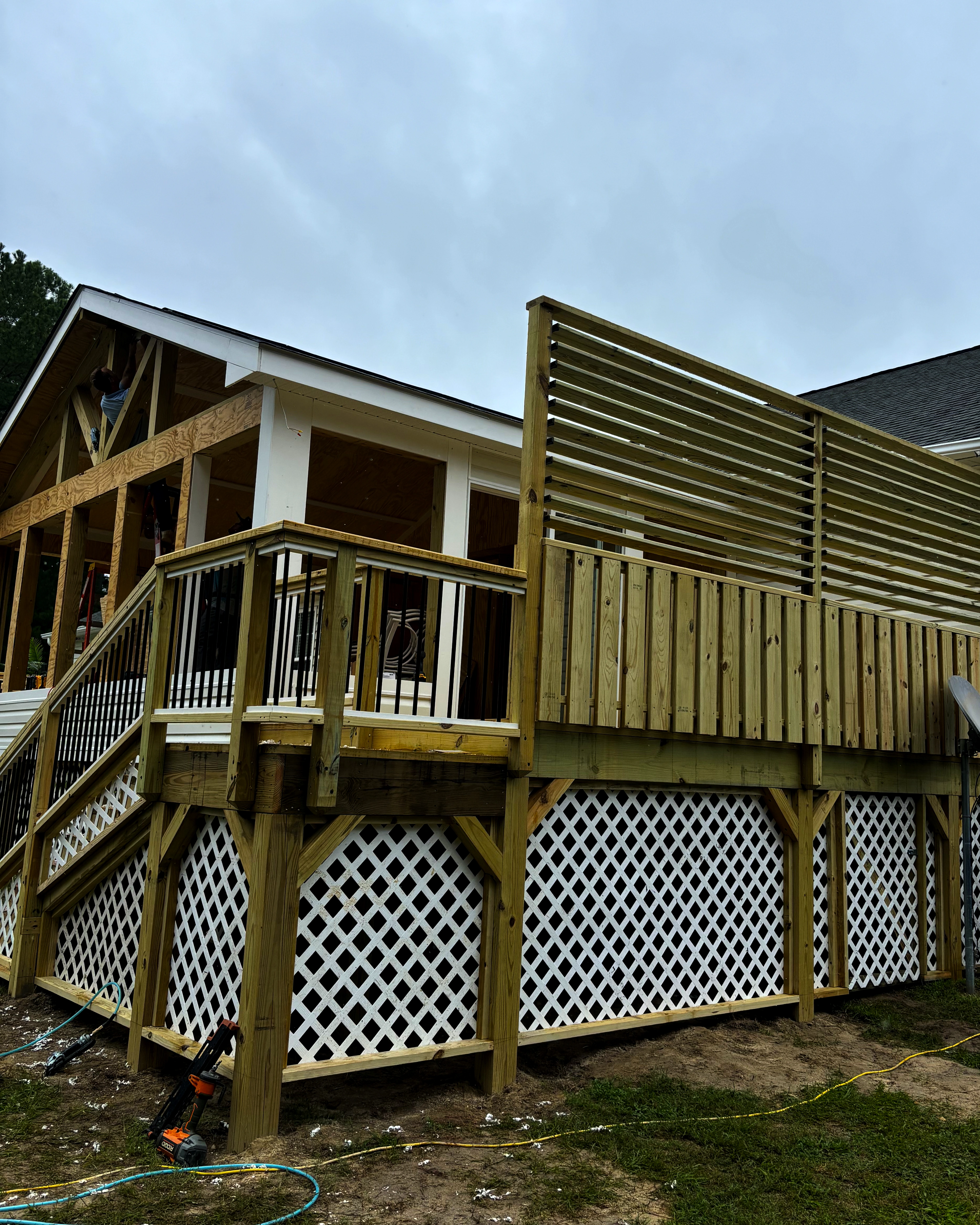 Tall horizontal-slat privacy screen installed on a finished deck.