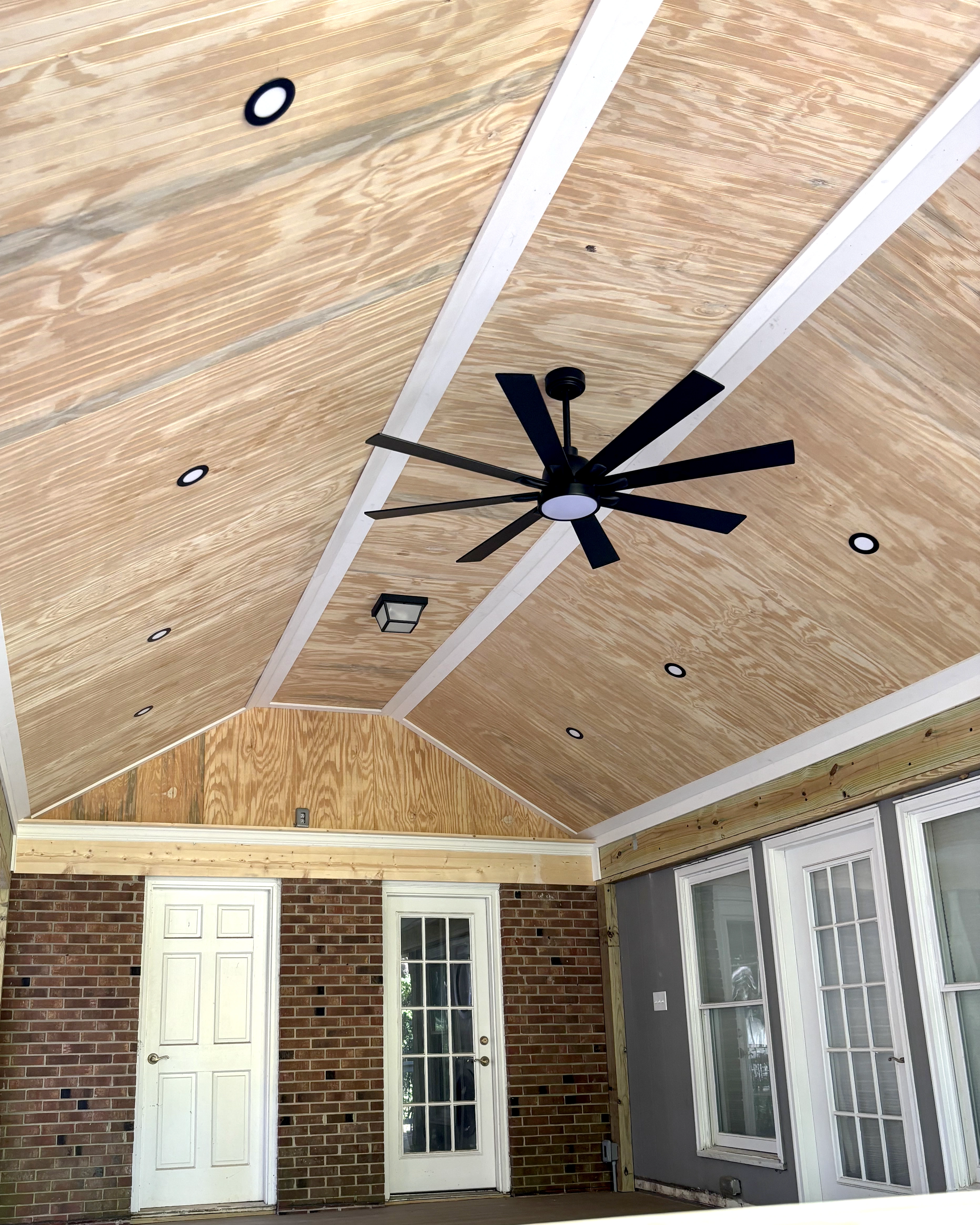 Screened porch ceiling with recessed lights and a modern ceiling fan.